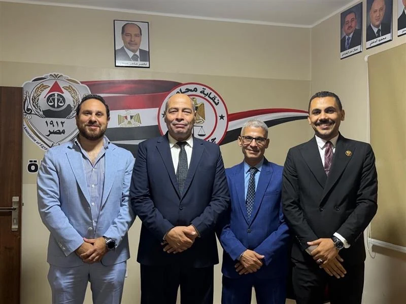 Four men standing in front of the Southern Giza Bar Association emblem